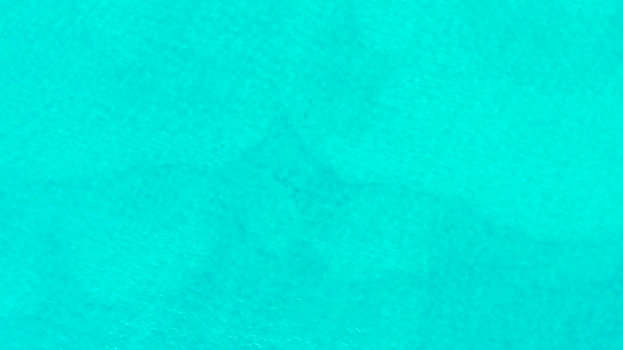 Clear turquoise water with subtle ripples and underwater shadow.