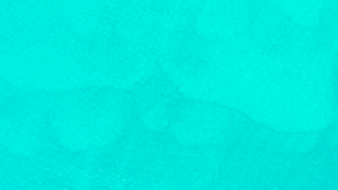 Clear turquoise ocean water at Laguna Beach Los Cabos fills the frame with faint sandy patterns under the surface and no visible people.