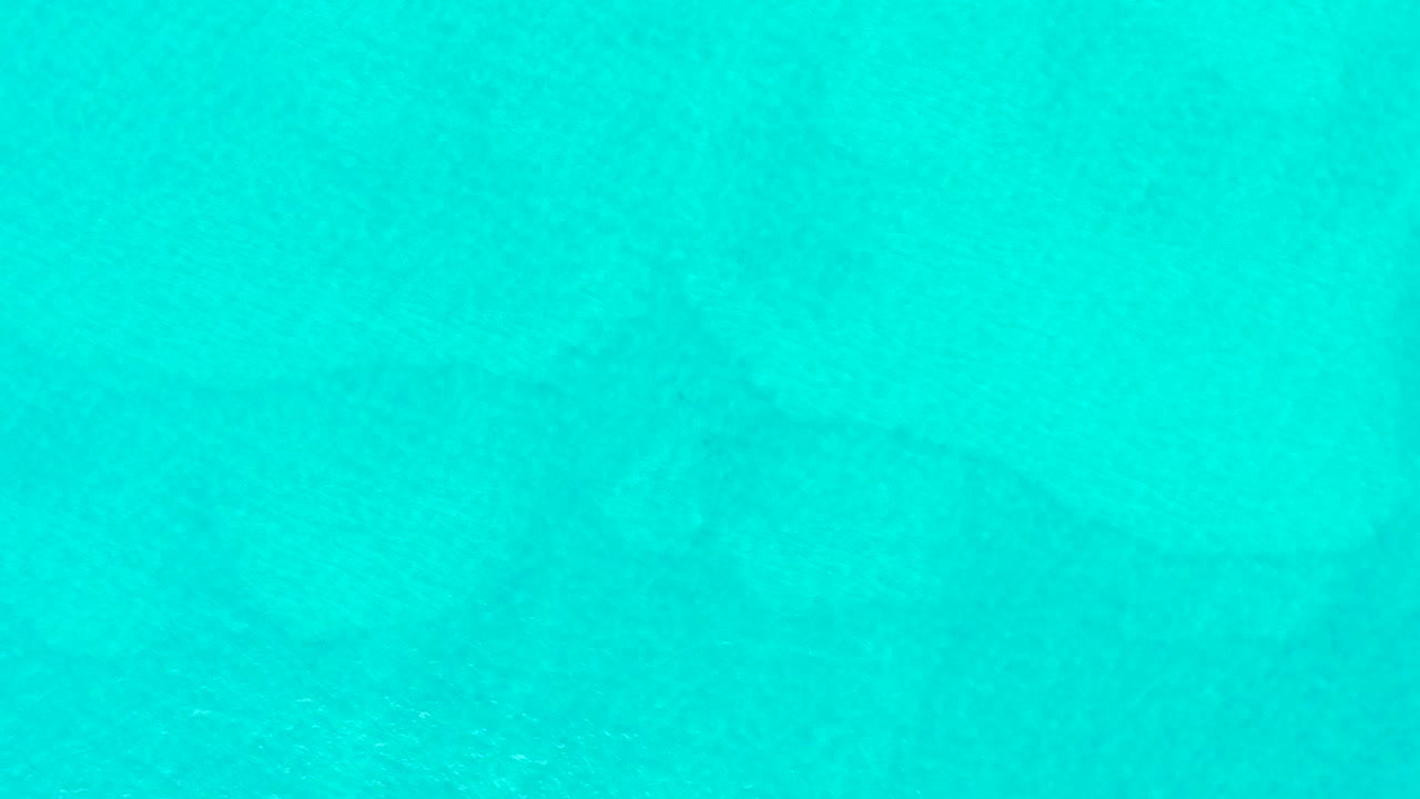 Blue-green transparent water at Laguna Beach Los Cabos shows subtle surface ripples and soft underwater texture, with no visible people.