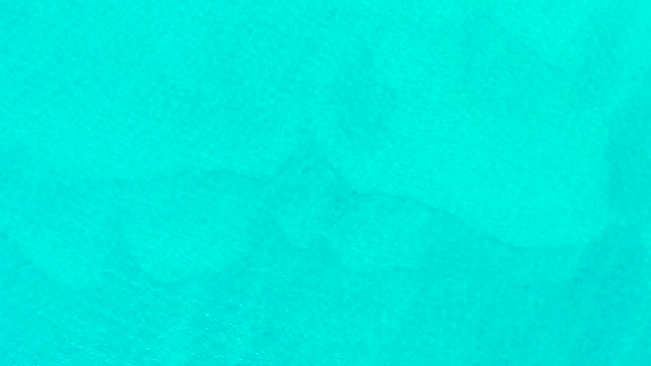At the start of the Laguna Beach Los Cabos clip, turquoise ocean fills the frame with a faint shark silhouette beneath the water and no visible people.