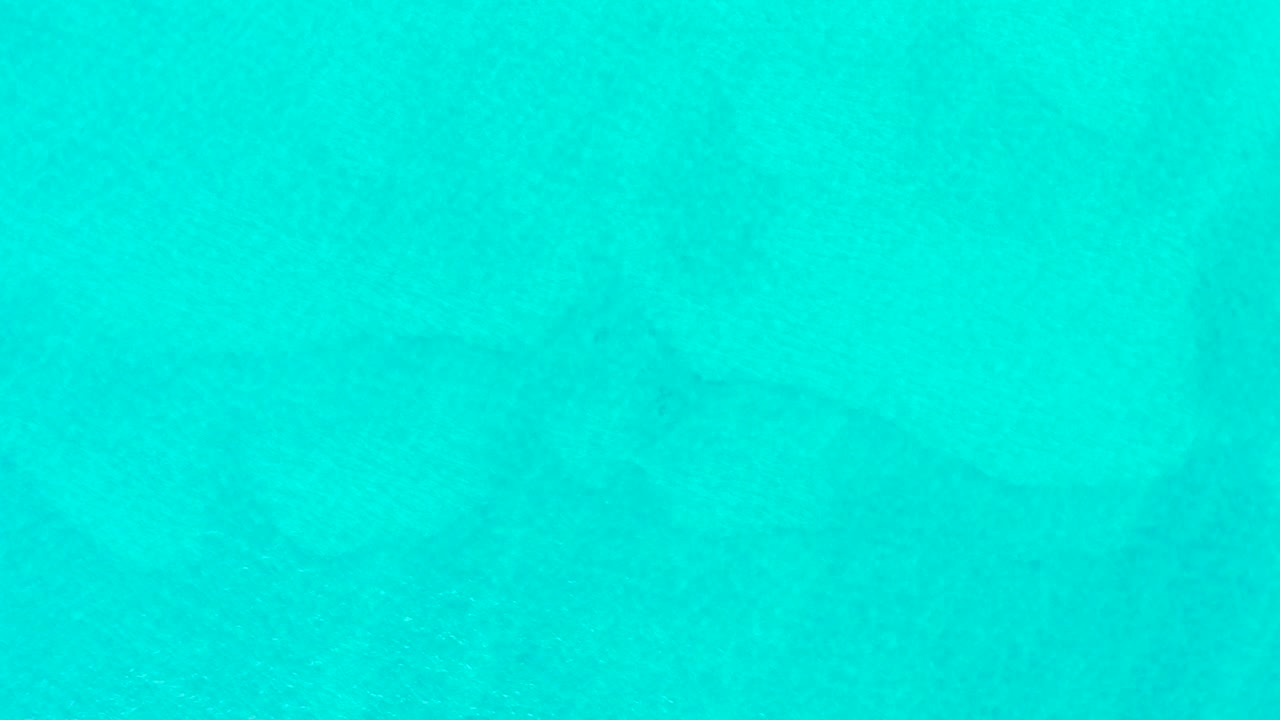 Clear turquoise water with the shark silhouette slightly farther across the frame.