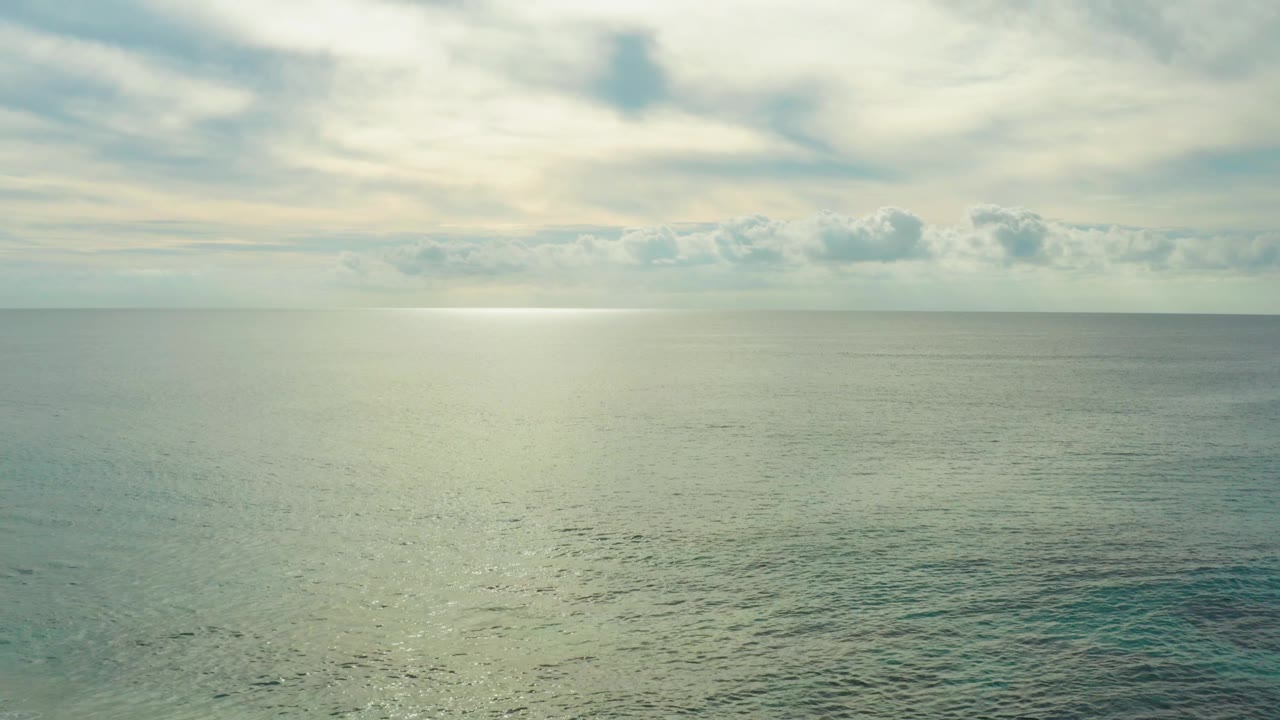 At Laguna Beach Los Cabos, blue-green ripples fill the lower frame while layered clouds sit above the horizon and no visible people appear.