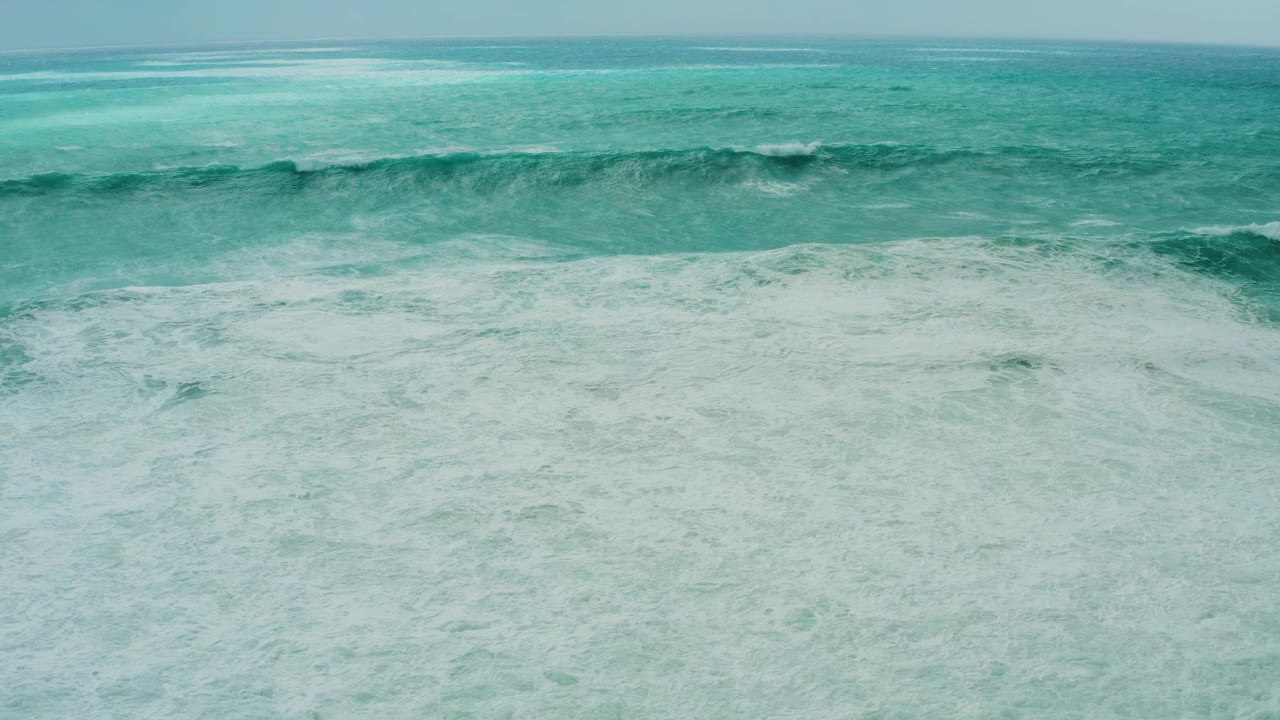At Dreams Resort Los Cabos, the midground crest starts to fold into whitewater above a wide field of pale foam, no visible people.