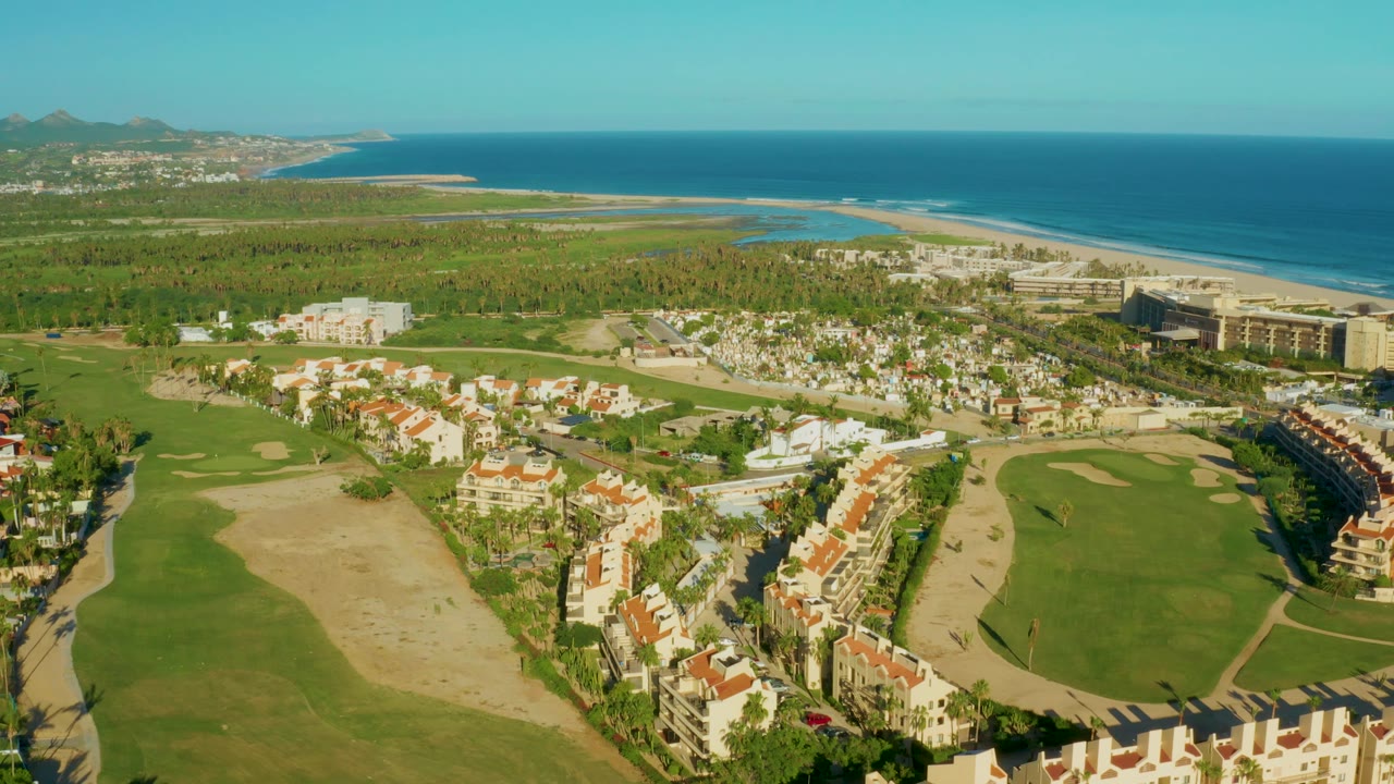 Aerial coastline view with golf fairways and residential buildings