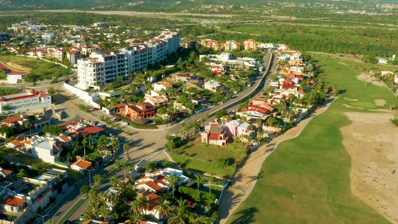 Drone view over a residential block and green golf fairway.