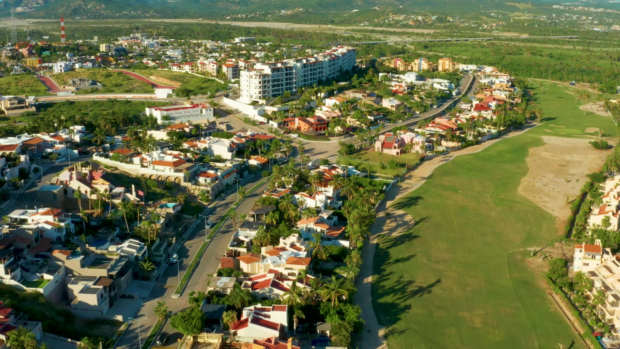 Elevated view of a suburban road network beside a green field.