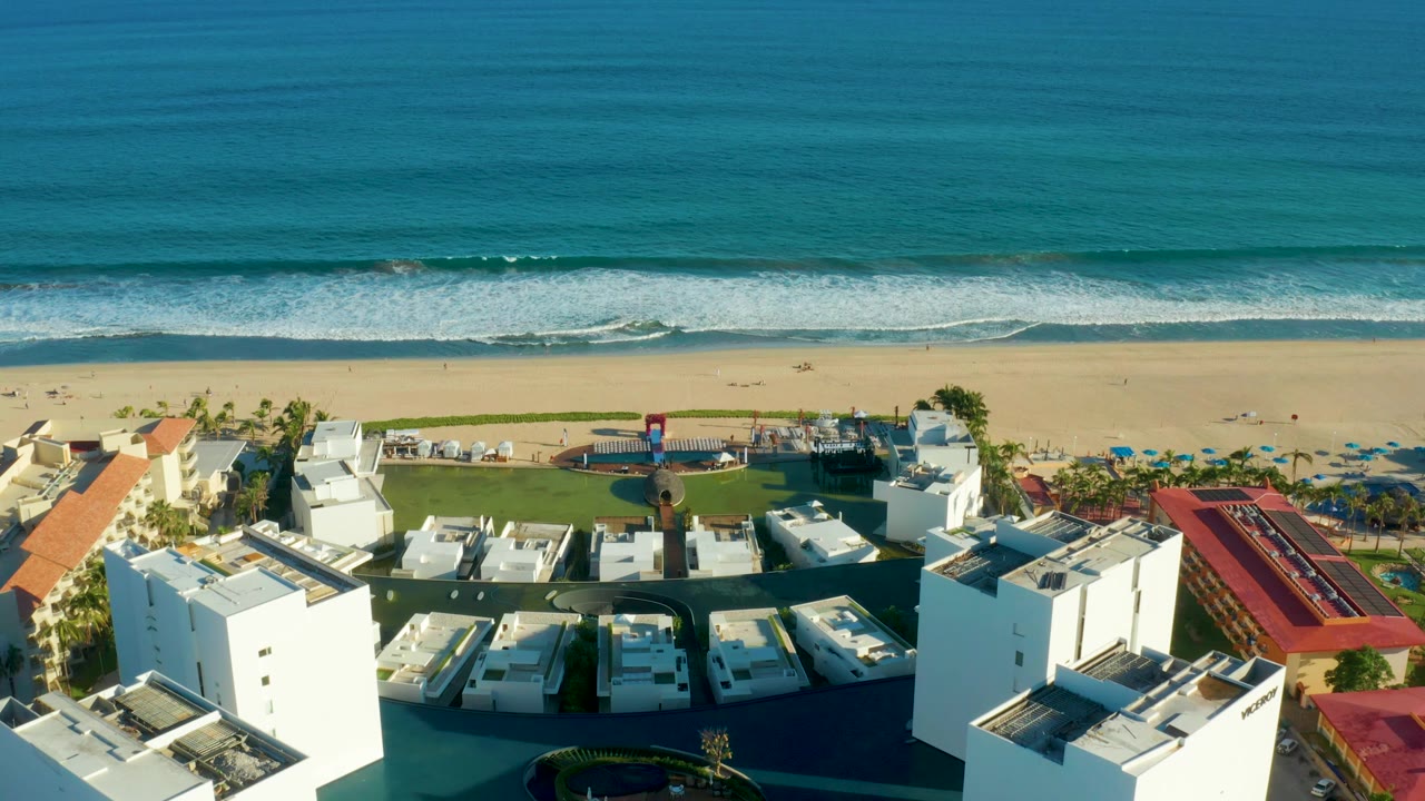 Aerial resort courtyard near sandy beach and blue ocean