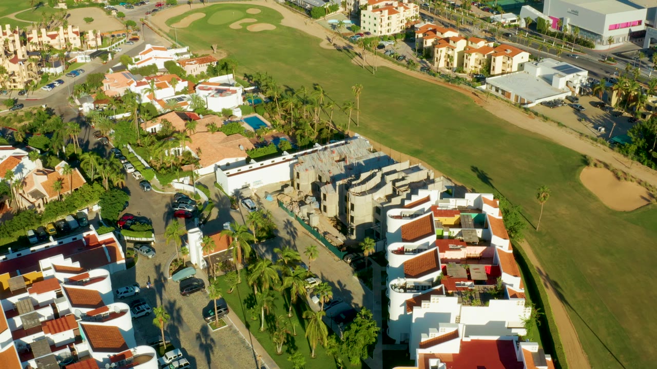 Drone view of residential streets and a green field