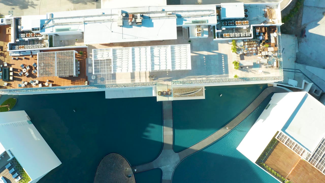 Rooftop pool area with building roof and nearby street edge.