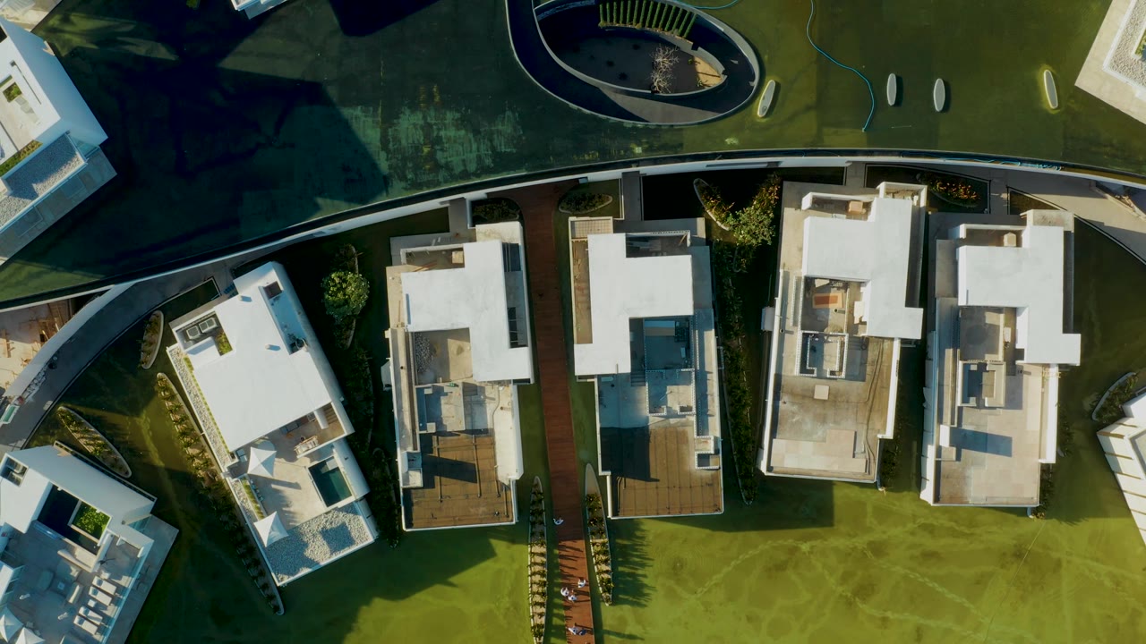 Top-down residential complex with white roofs and green open space.