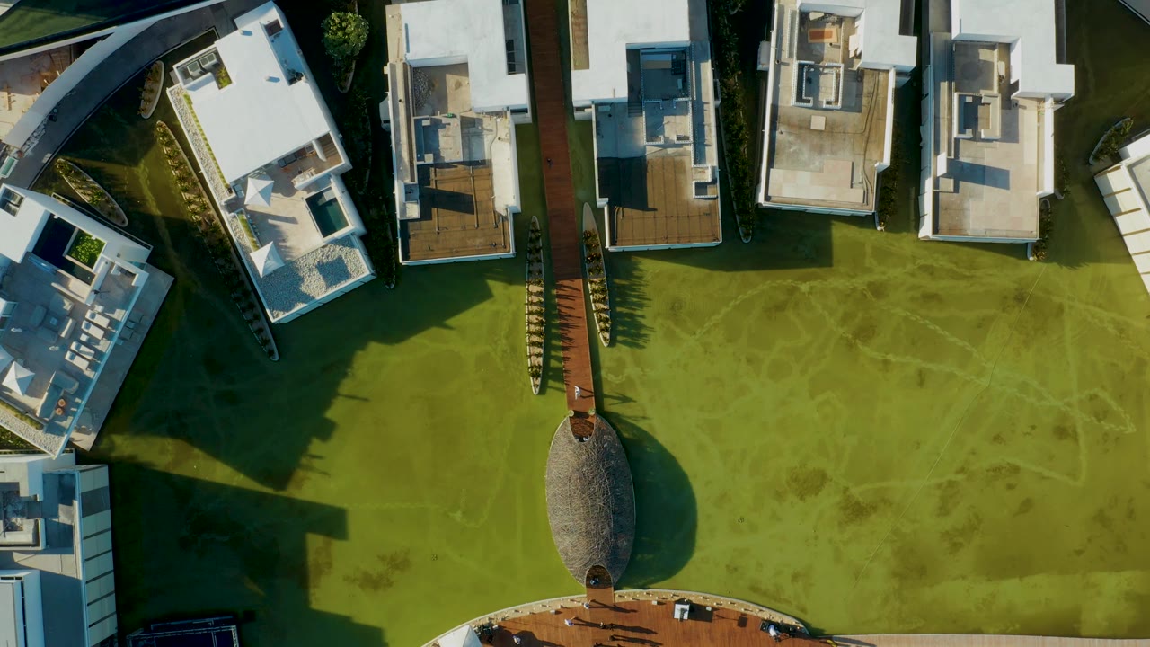 Overhead lawn and central path between modern white residential buildings.