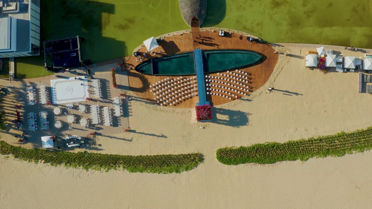 Aerial pool deck beside sand seating and green lawn