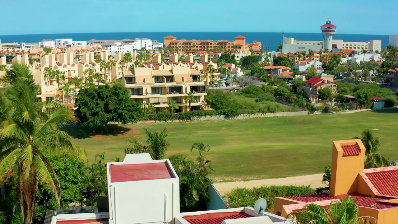 Residential blocks and green field with ocean visible in the distance.