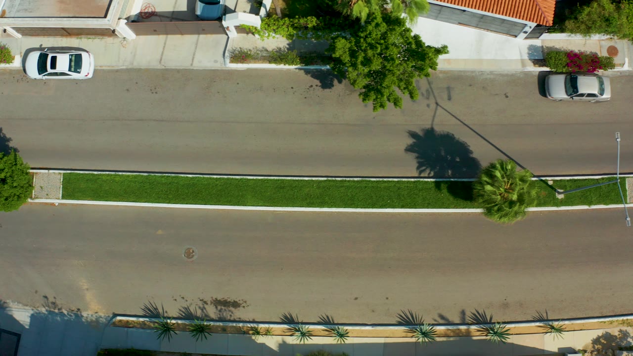 Overhead road with parked cars and median strip.
