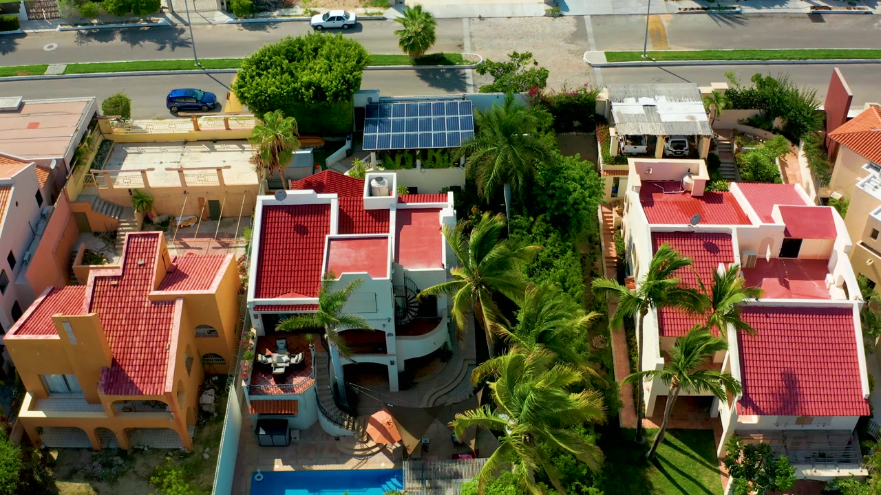 Aerial frame of houses, pool, palms, and road