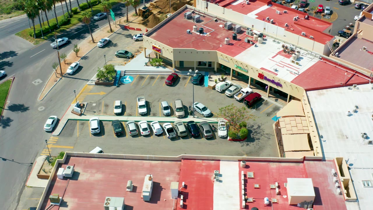Parking lot with cars below red commercial roofs