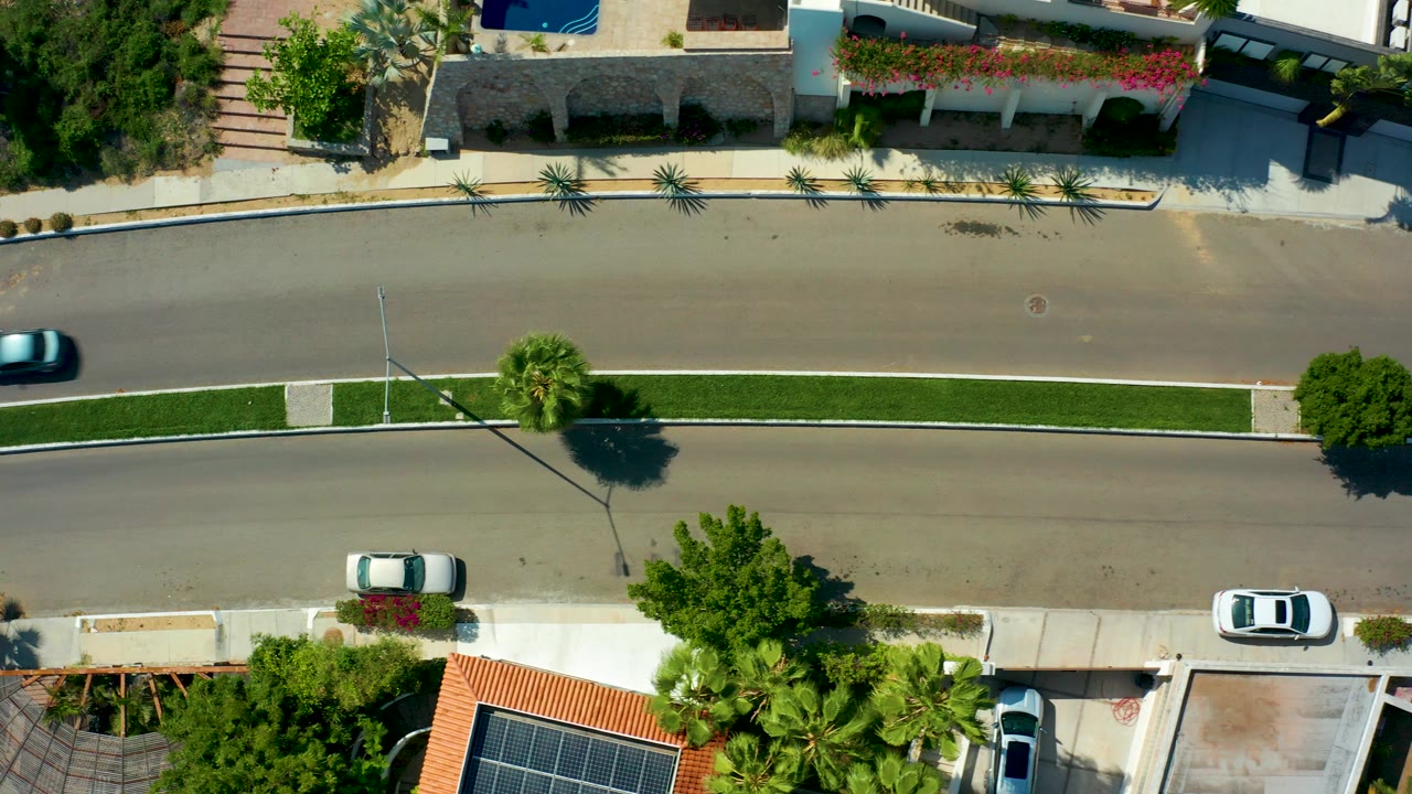 Overhead road scene with the blue car partly leaving the left edge of the frame.