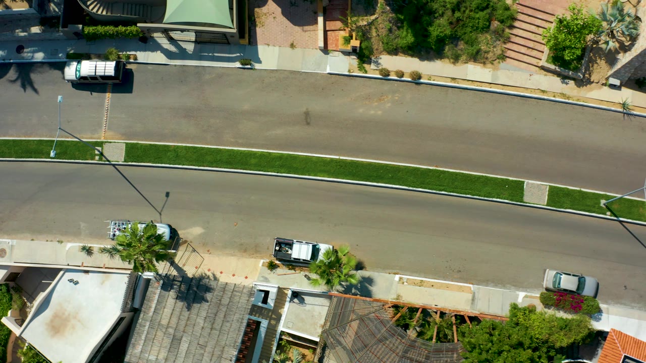 Overhead road scene with houses, trees, and a white van at the top.