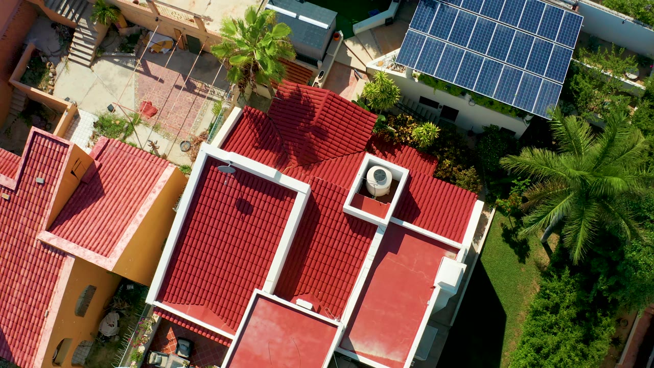 Red tile rooftops and tropical landscaping seen from a high drone angle.