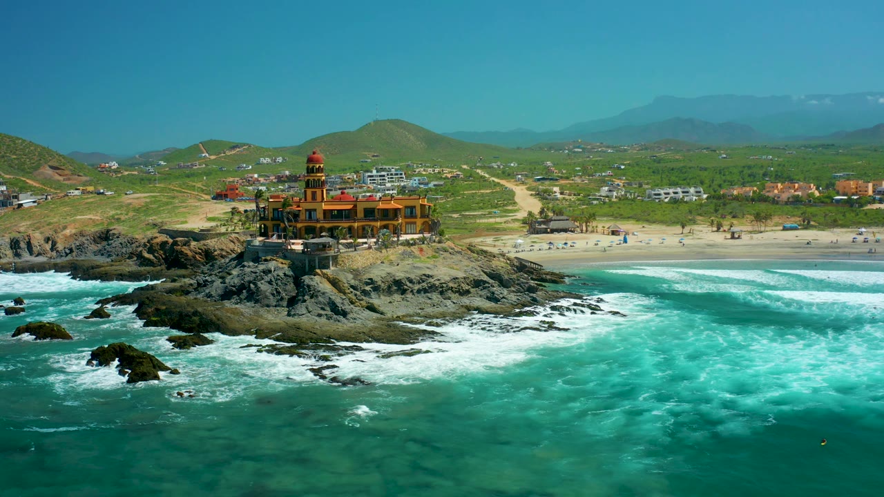 Aerial beach coastline with lighthouse on rocks and turquoise water