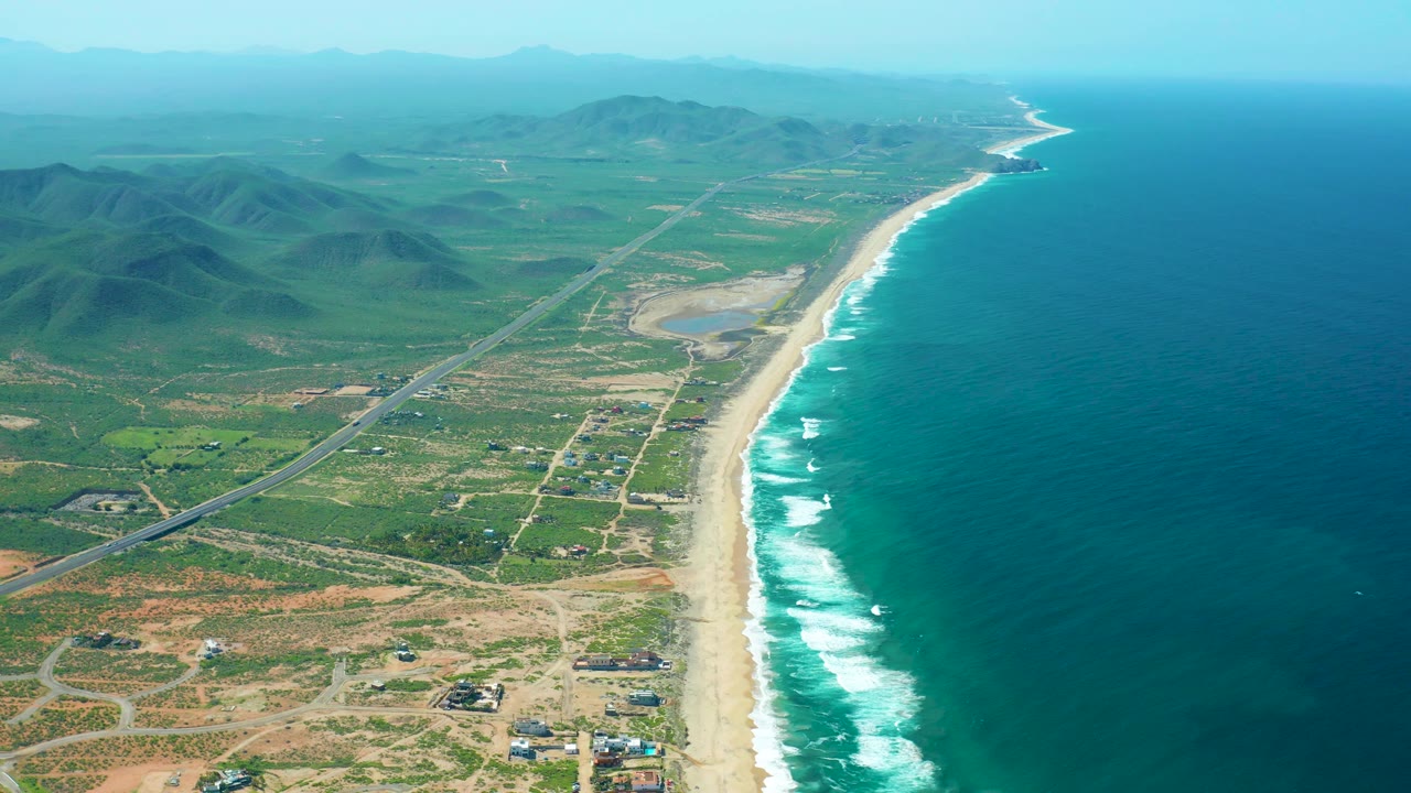 Hazy aerial coastline with beach, highway, hills, and ocean