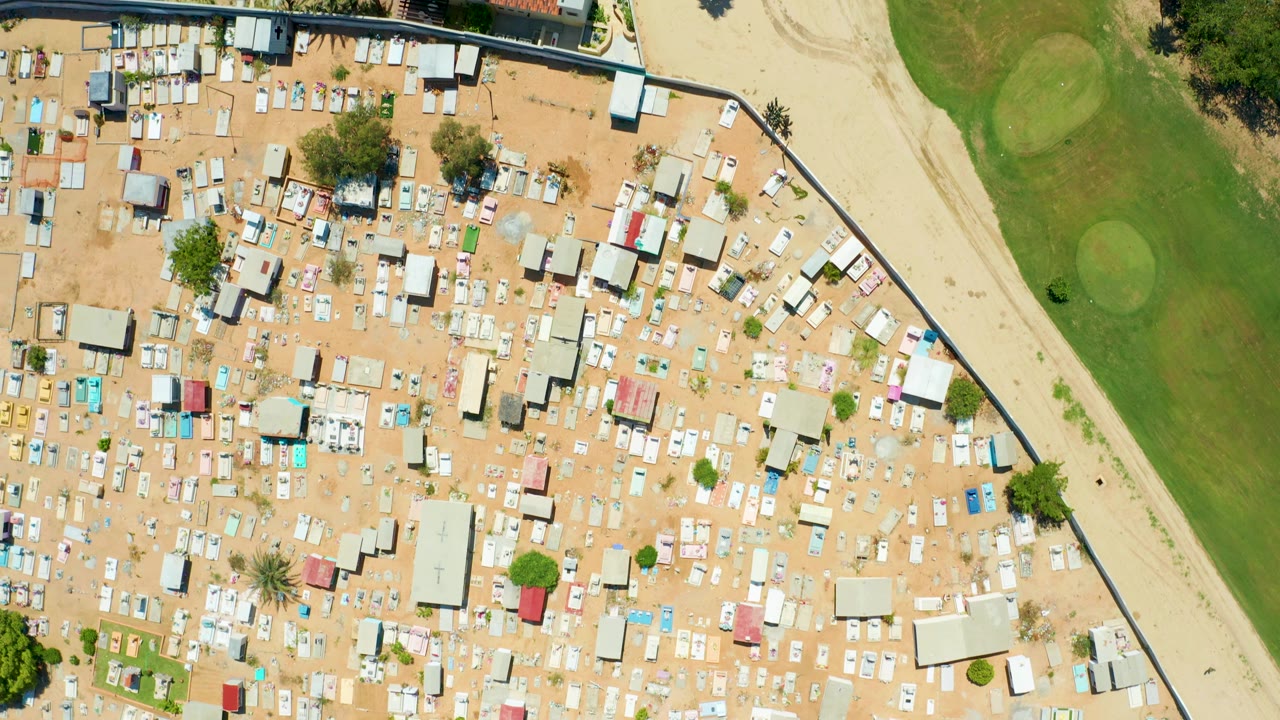 San Jose del Cabo aerial frame showing the compact residential grid, a curved grass area, a sandy strip, and scattered trees, with no visible people.