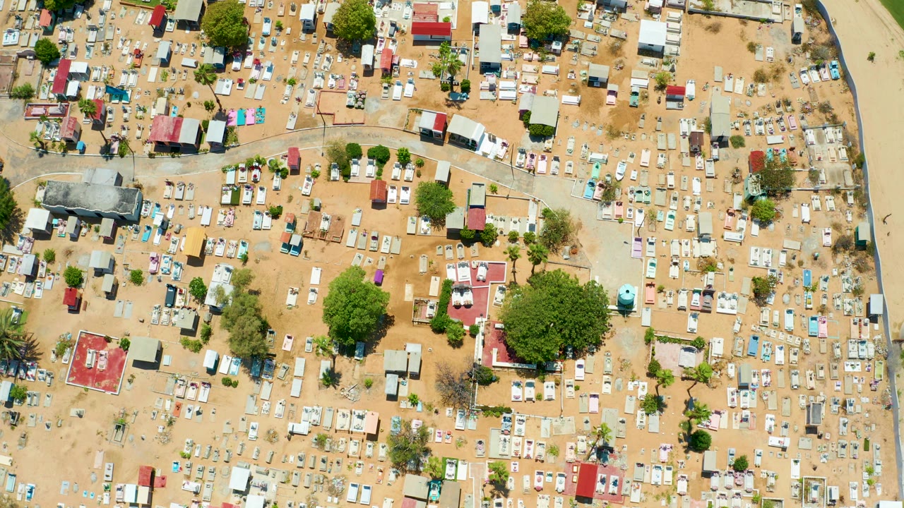 A second overhead view in San Jose Del Cabo shows rows of white grave markers, red and light roofs, dry sandy lanes, green trees, and no visible people.