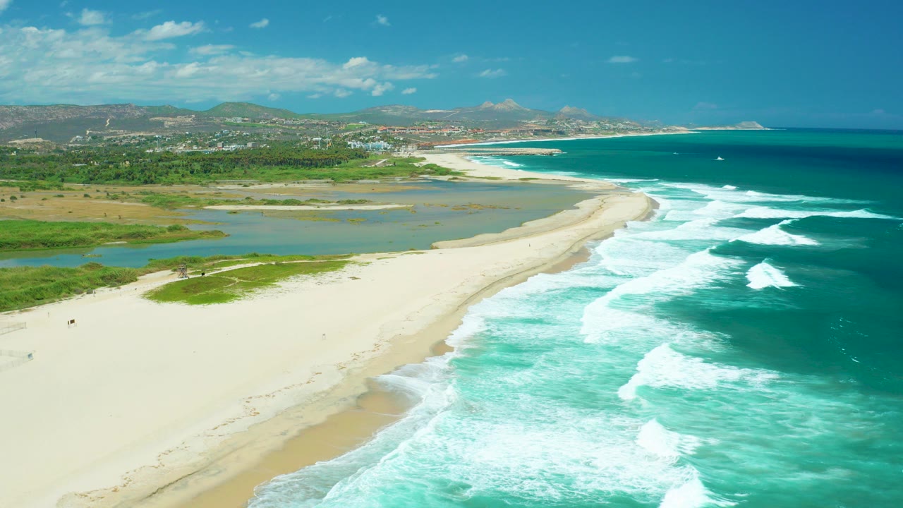 Aerial view of sandy beach between lagoon and ocean surf