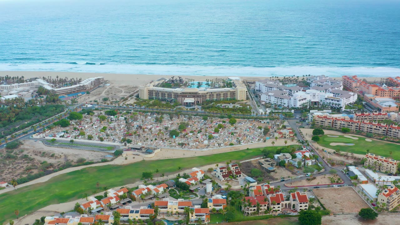 Aerial view of oceanfront buildings, road, golf course, and demolished ground area.