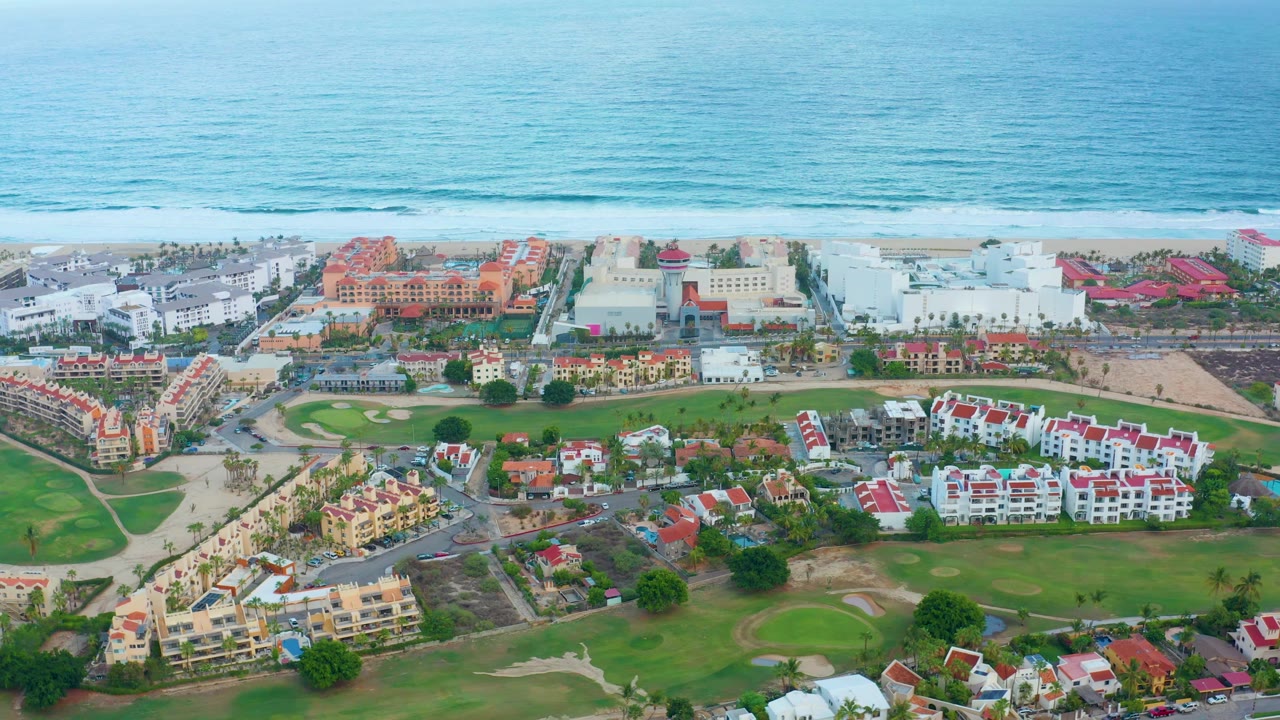 Ocean waves behind beachside residential buildings.