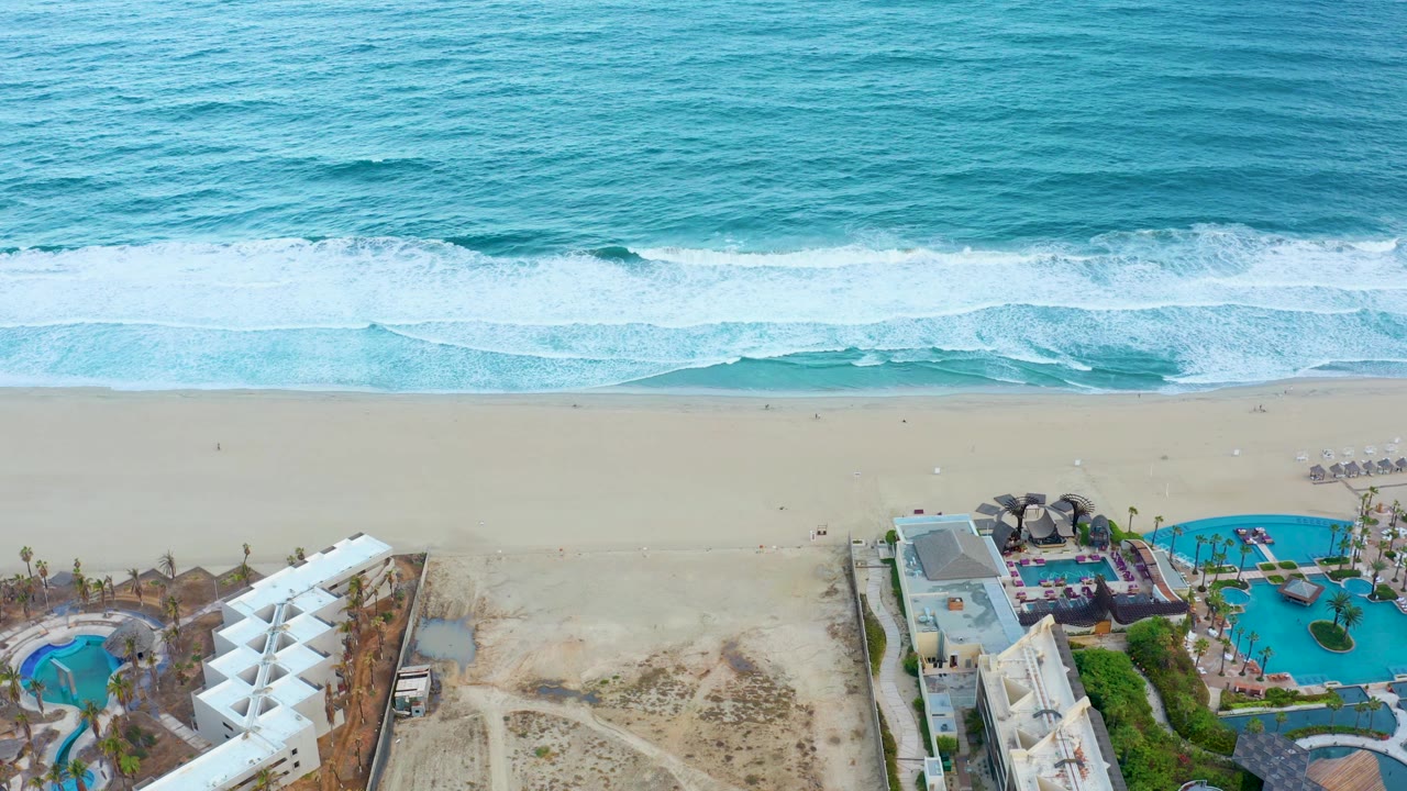 Aerial shoreline with resort buildings and open sand