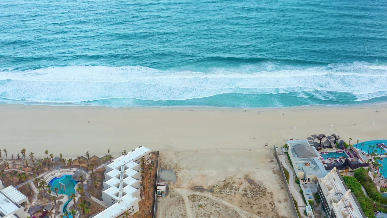 Aerial shoreline with resort buildings and pools