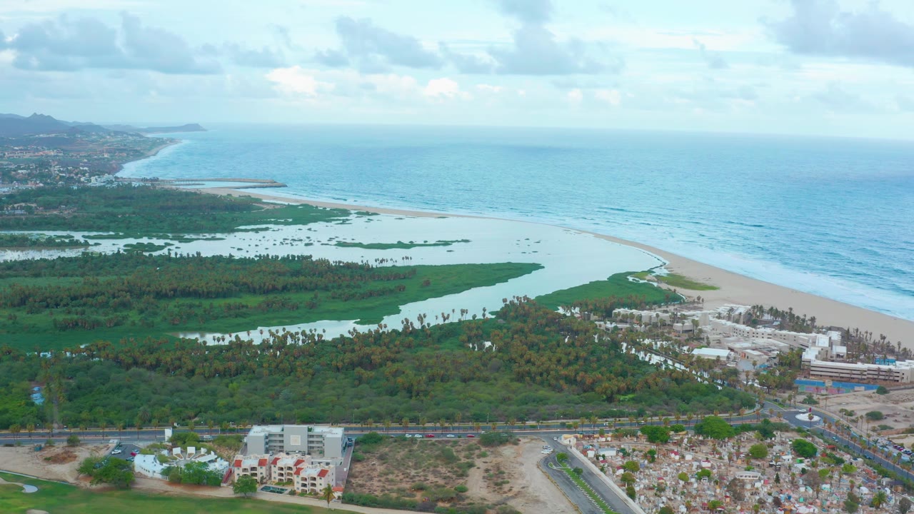 Aerial beach and lagoon with wetlands and developed lots below.