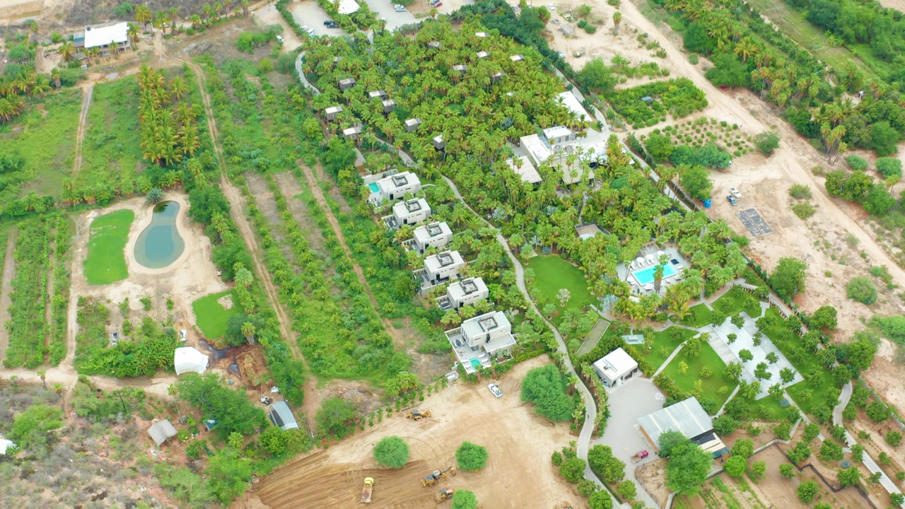 Aerial farm property with pond, orchard-like rows, buildings, and blue pool.