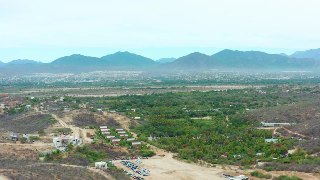 Aerial rural view with mountains on the horizon and dirt roads below.