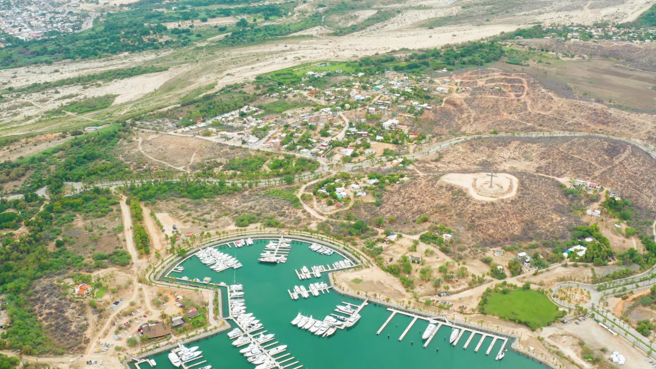 Aerial marina scene with docks, boats, roads, and arid hills.