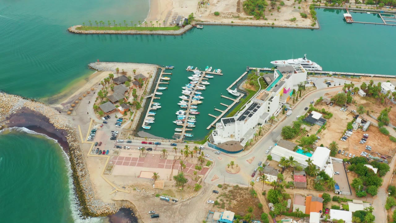 Overhead marina scene with breakwater, docked boats, and waterfront road