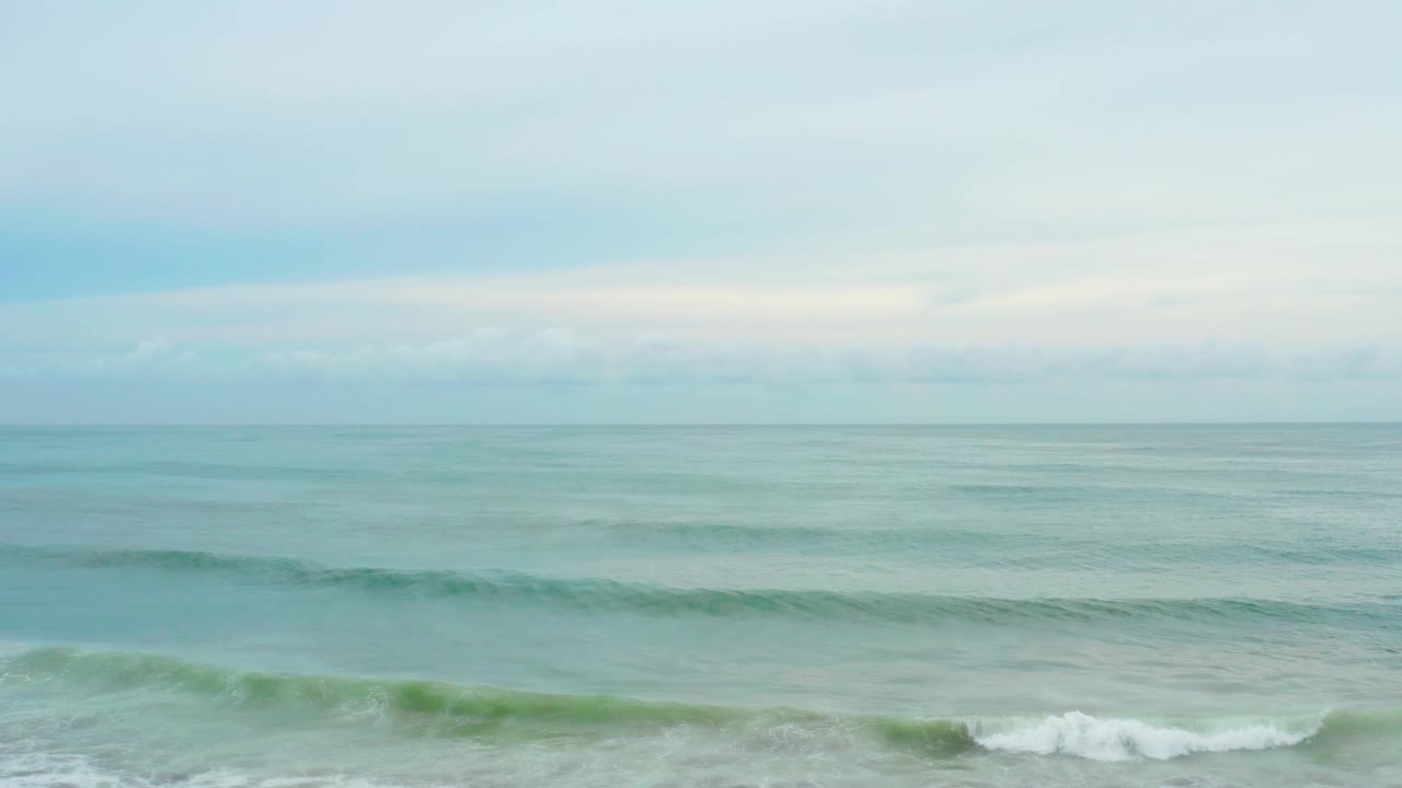 At La Playita Los Cabos, a small surf line breaks into white foam near the bottom while calm water fills the center, with no visible people.