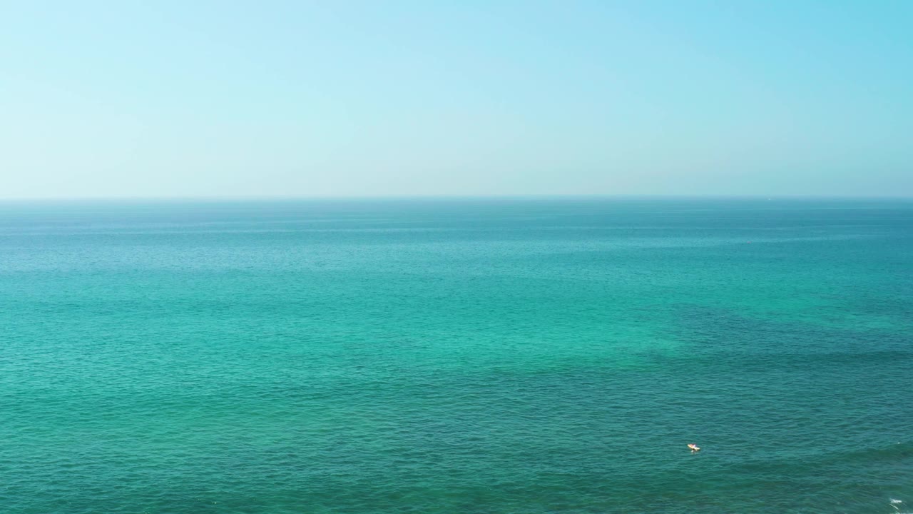 Fourth frame holds a broad El Tule Beach water view, with pale sky above, darker turquoise patches across the midground, the buoy low near center, and no visible people.