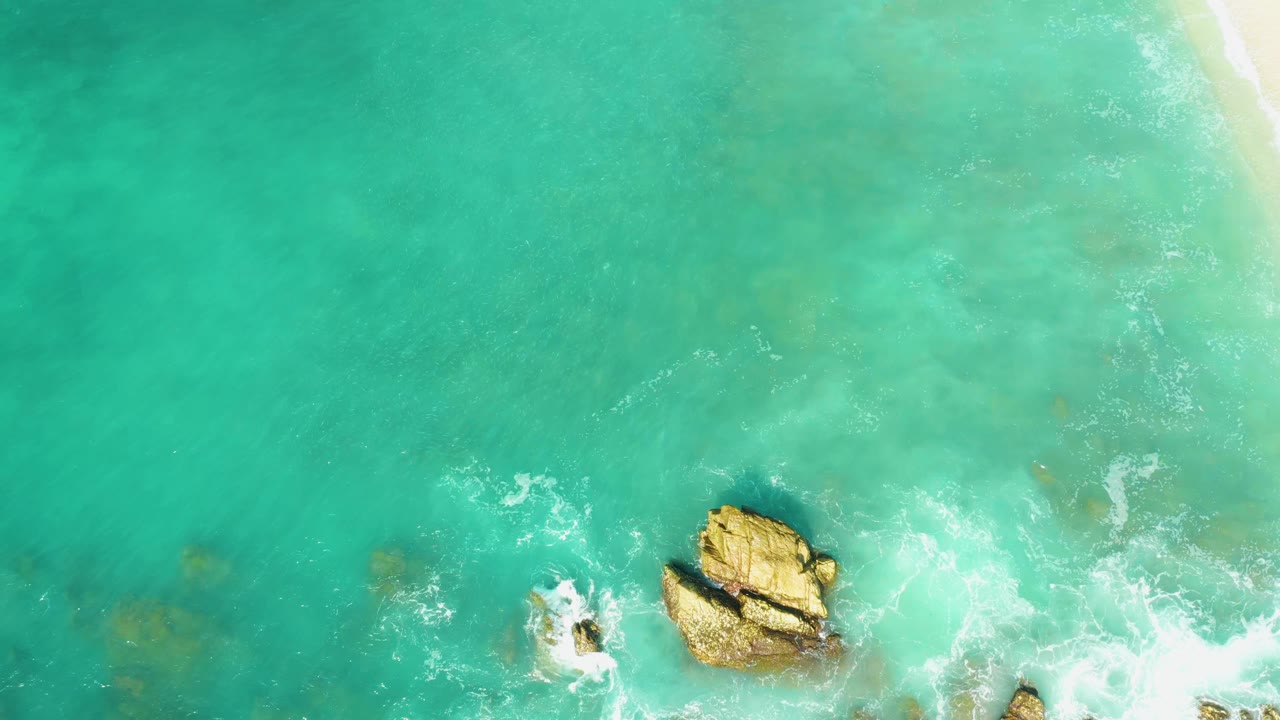 Overhead turquoise water with rocks and white surf near the shore