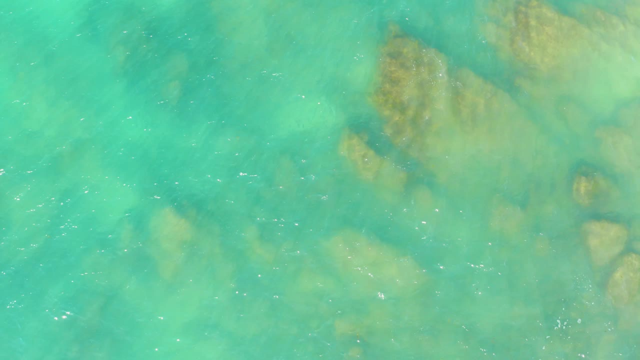 Shallow green-blue water with soft rock shapes