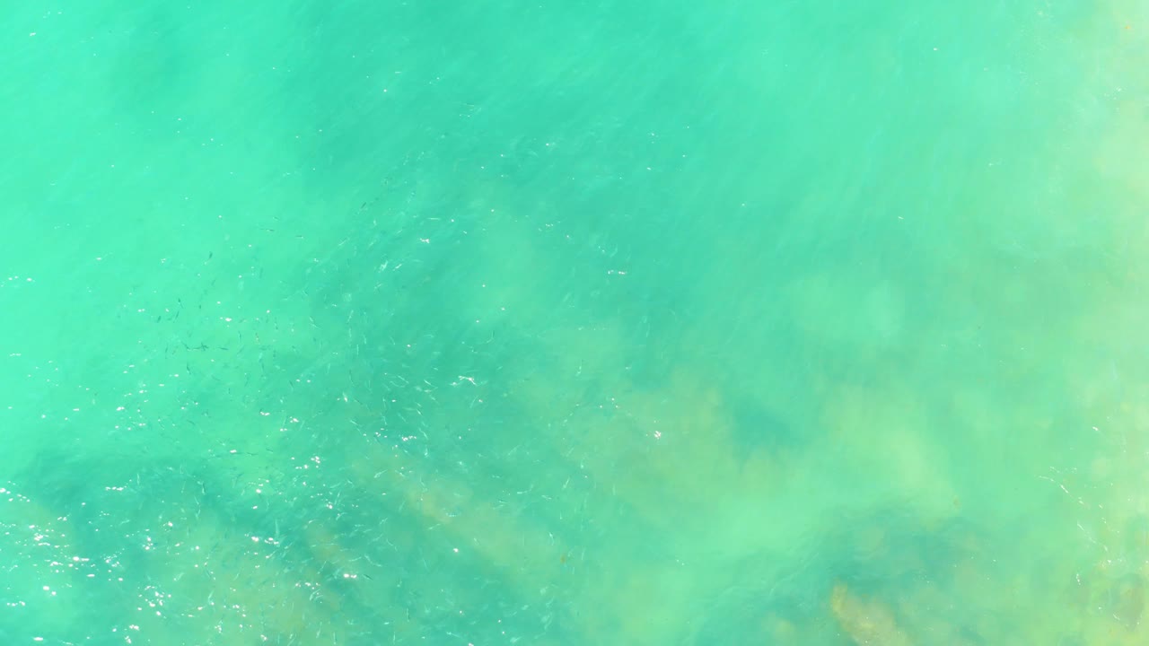 Shallow turquoise water with cloudy light patterns over the seabed.