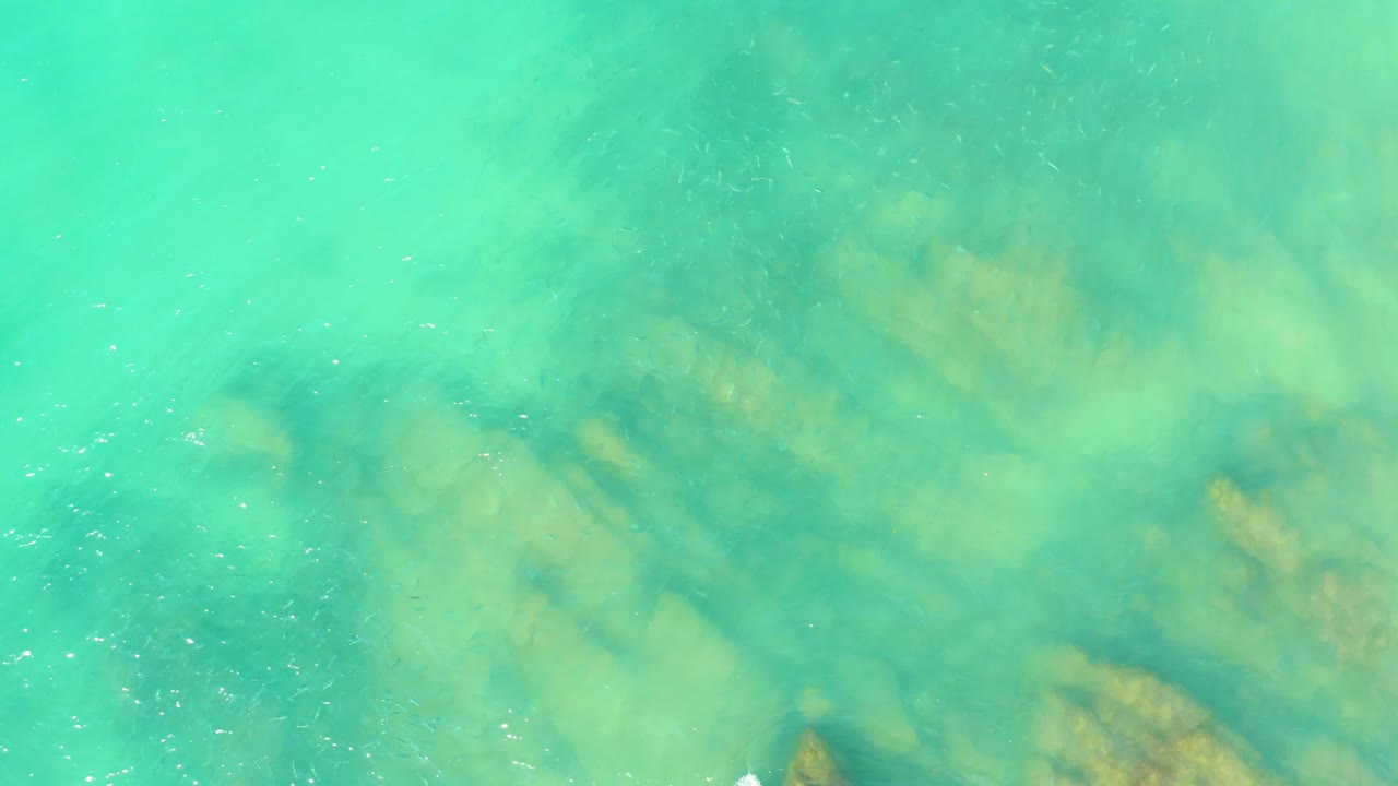 Shallow ocean water with blurred rocky bottom.