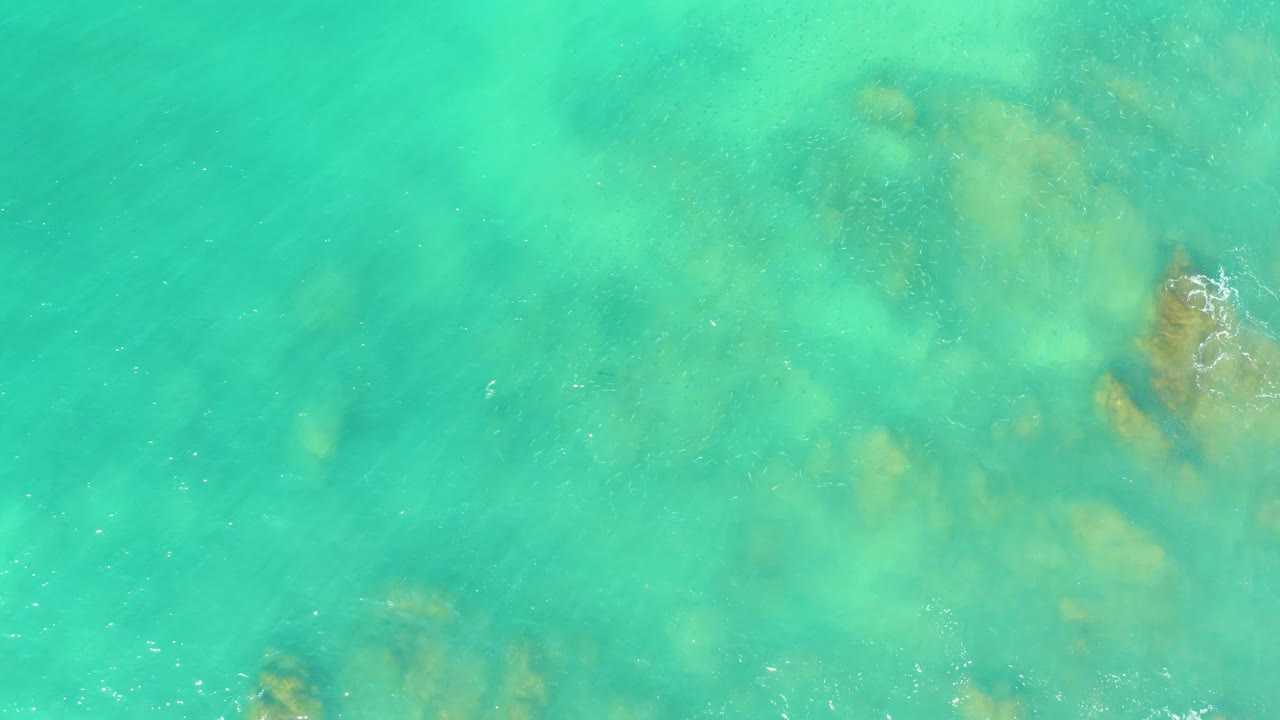 Clear green-blue water with rocky seabed under the surface.
