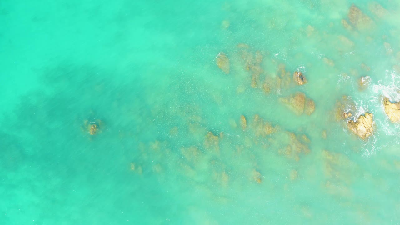 Clear green-blue water with rocks visible below the surface.