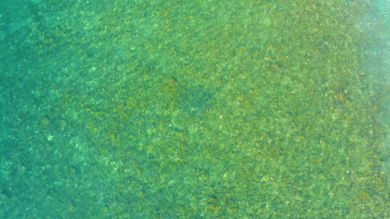 Shallow ocean water at El Tule Beach Los Cabos has brighter refracted patches across the sea floor and no visible people or structures.