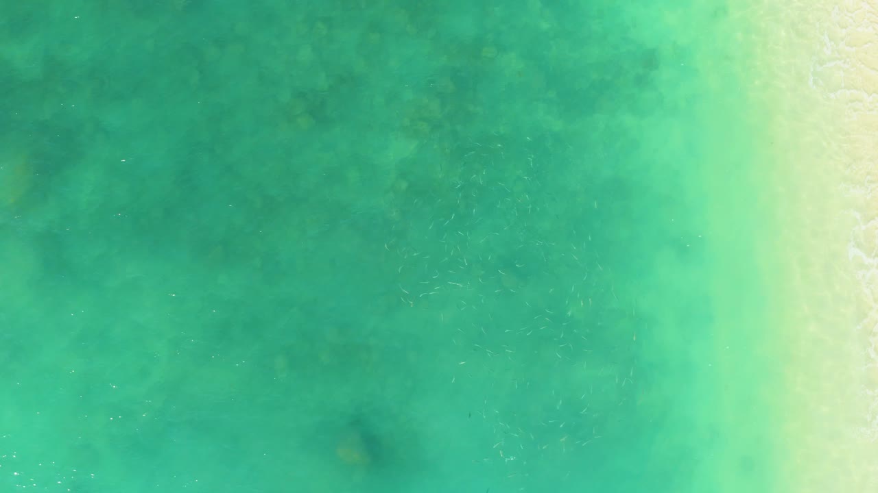 Turquoise water with faint seabed patches near shore