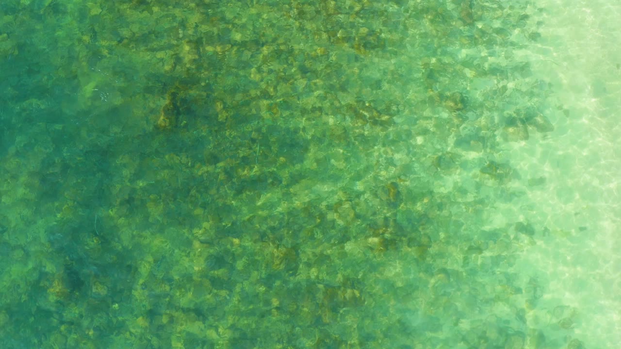 Clear green-blue shallow water over a rocky bottom.
