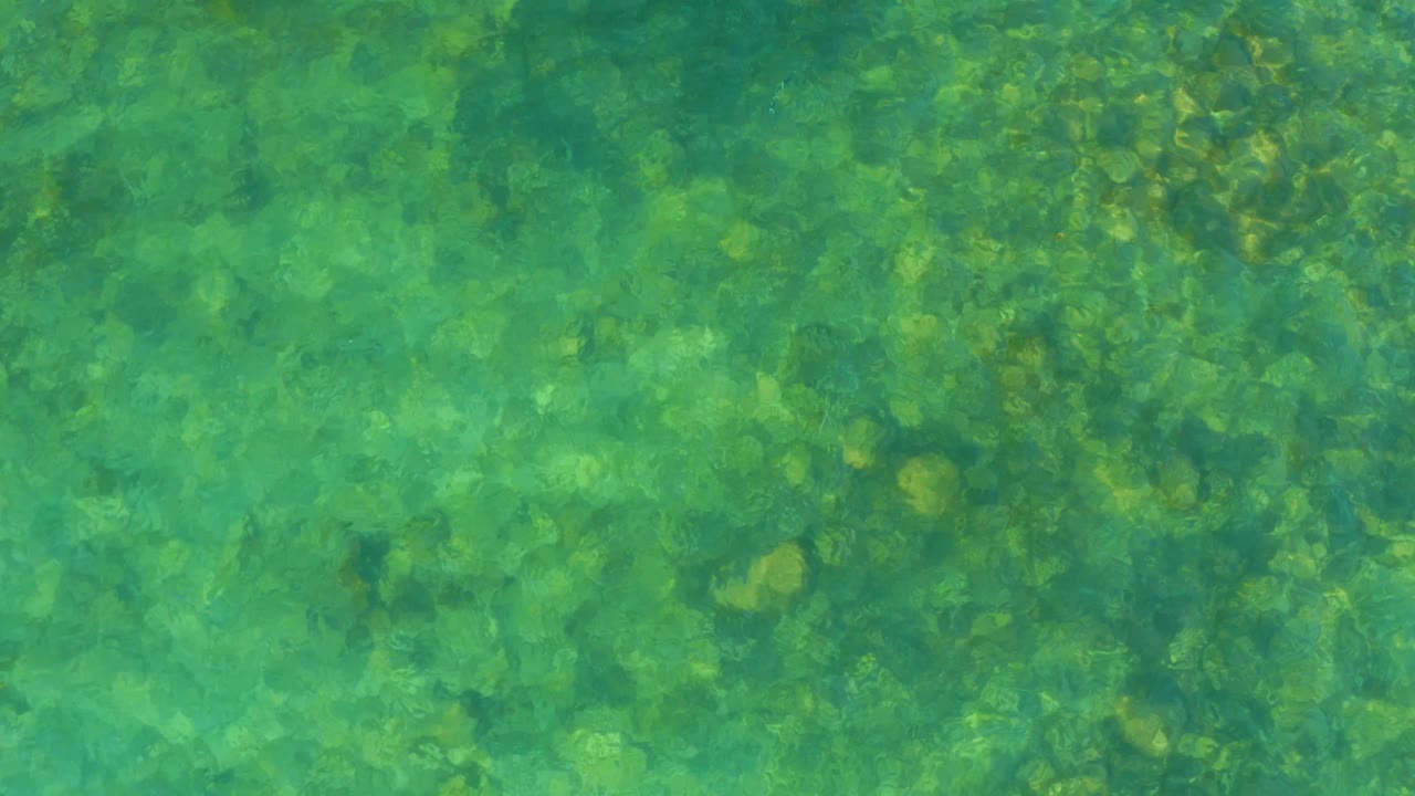 Light and shadow moving over underwater stones