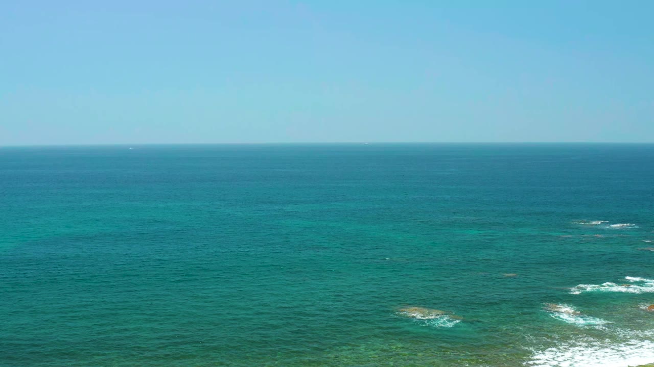 Wide blue ocean with turquoise shallows and small breaking waves